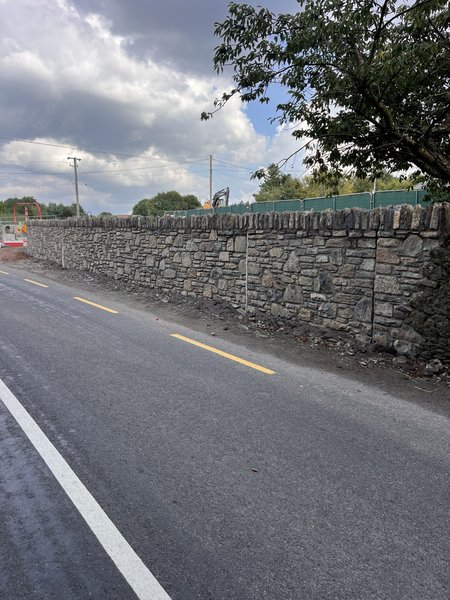 Finished roadside stone boundary wall with upright coping beside the newly surfaced Water Rock Road, Midleton